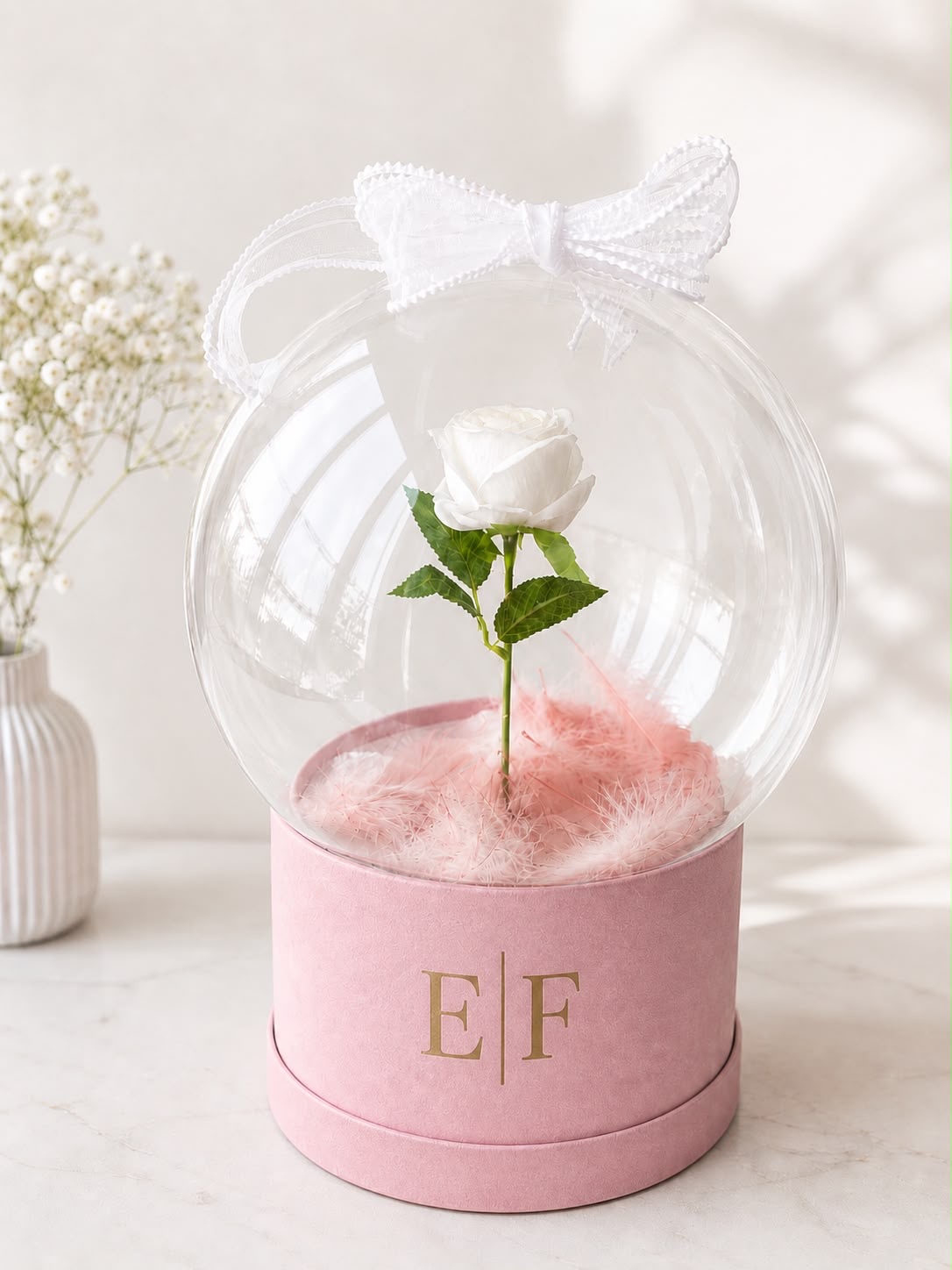 Preserved white rose in a glass dome on a blush pink EF monogrammed box
