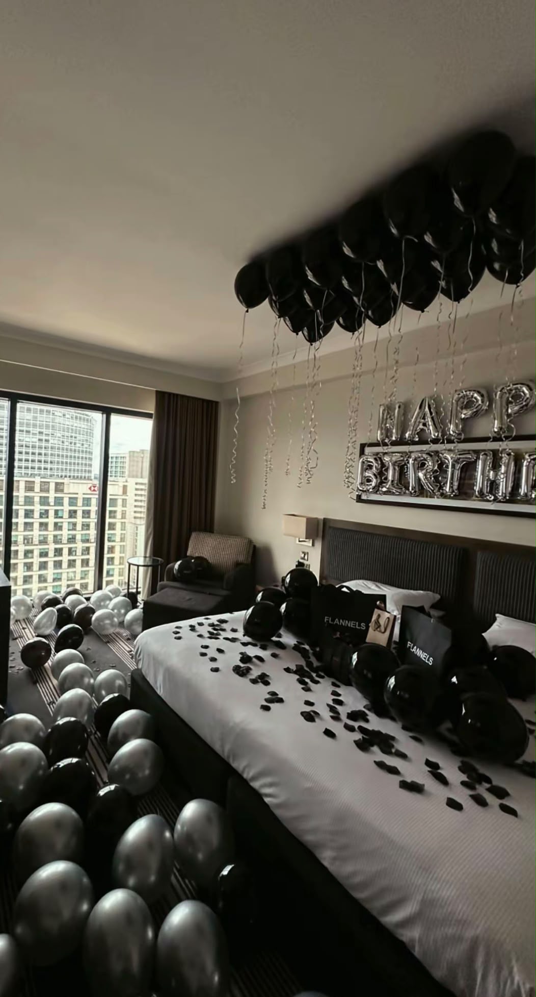 Happy Birthday suite in black balloons with black rose petals and city view
