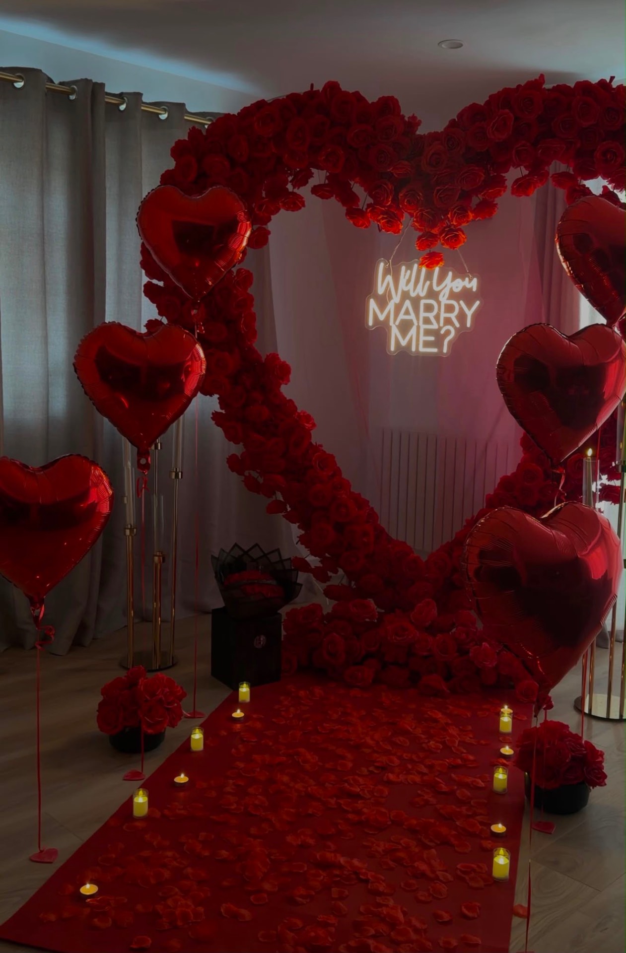 Indoor proposal rose heart with red carpet, candles and heart balloons