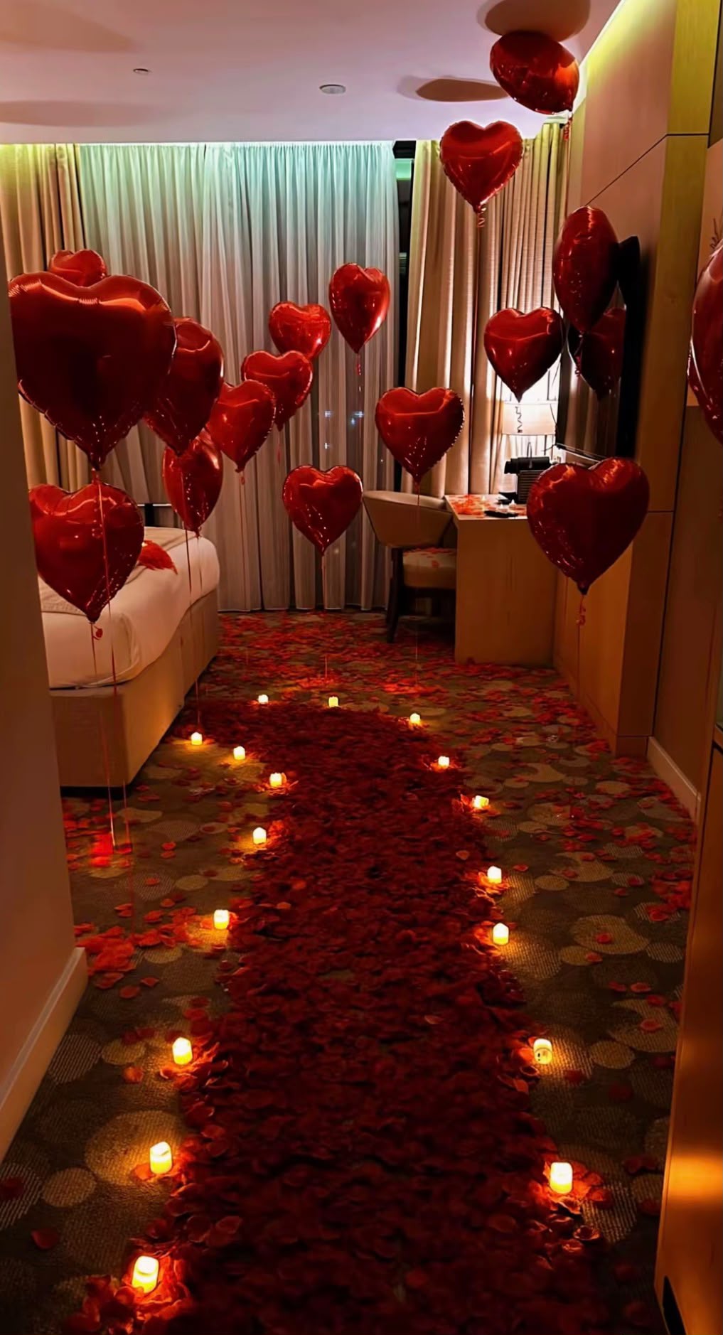 Candlelit rose petal pathway with red heart balloons